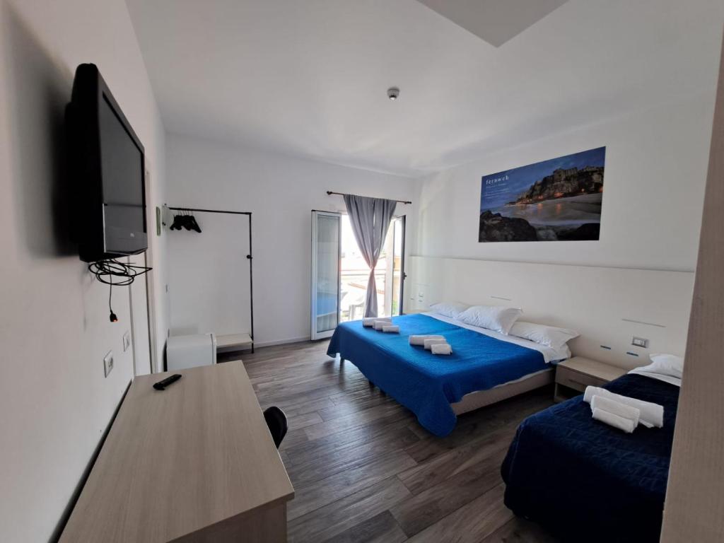 サンタ・ドメーニカにあるHotel Umbertoのベッド2台、薄型テレビが備わるホテルルームです。
