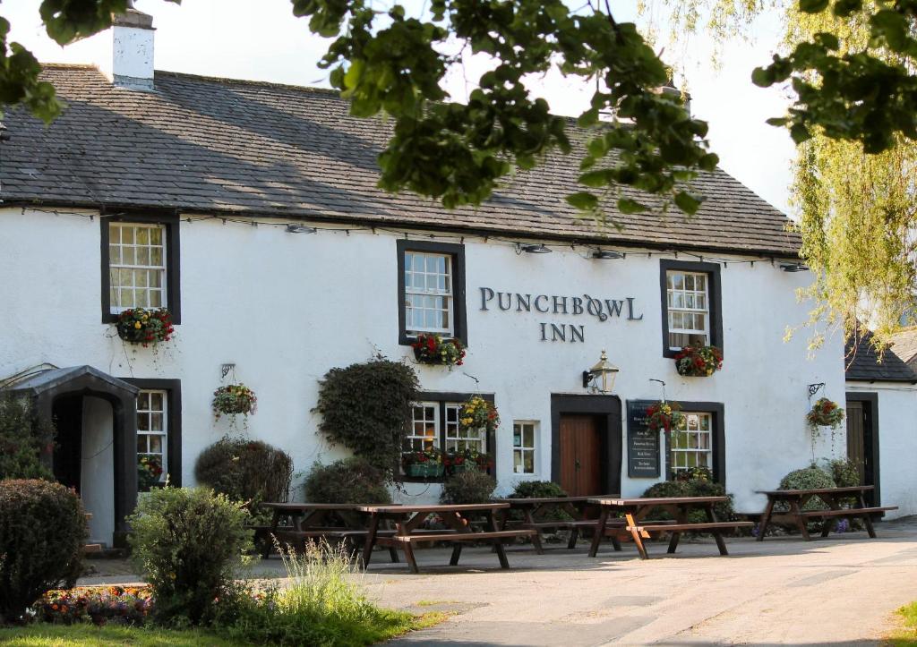 un bâtiment blanc avec bancs devant lui dans l'établissement The Punchbowl Inn, à Askham