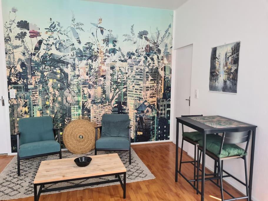 une chambre avec deux chaises, une table et une fresque murale. dans l'établissement Studio avec terrasse et place de parking, à Toulouse