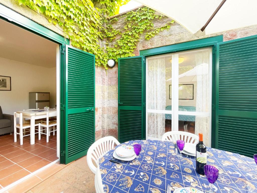 een eetkamer met groene deuren en een tafel en stoelen bij Sant'Anna del Volterraio - Strada Maestra (56) in Bagnaia