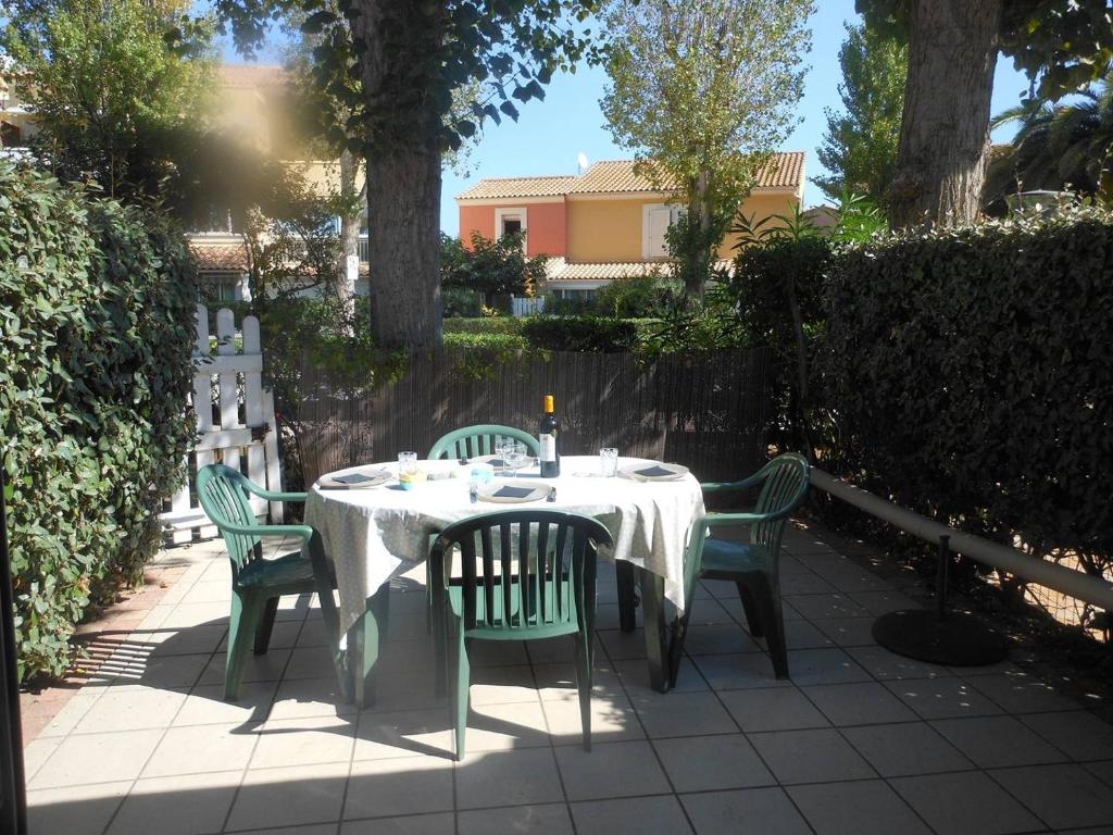 une table avec quatre chaises et un tissu de table blanc dans l'établissement VILLA 3 pièces, 47m2 + TERRASSE 15m2 REF 4004, à Le Castellas