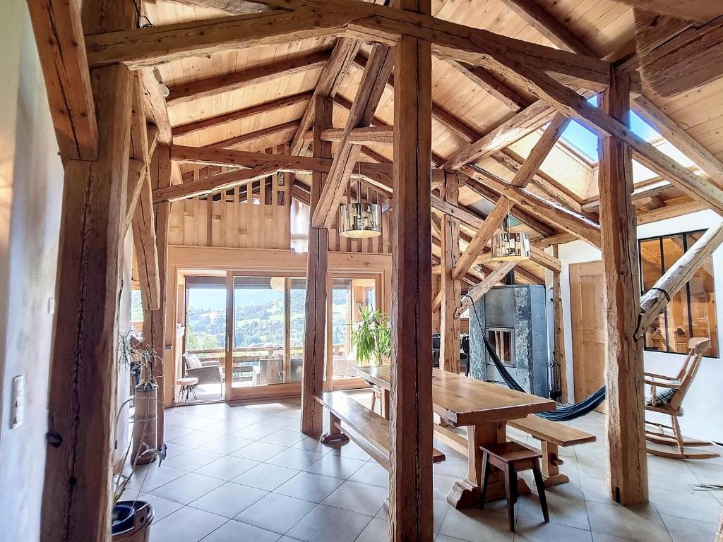 Cette grande chambre en bois comprend une table en bois. dans l'établissement Appartement dans Ferme Authentique à Cordon - Parking, Wifi, 2 à 4 mois Hiver, 15 jours Eté - FR-1-560-109, à Cordon