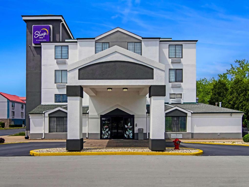 a white building with a purple sign on it at Sleep Inn near I-80 and I-94 in Lansing