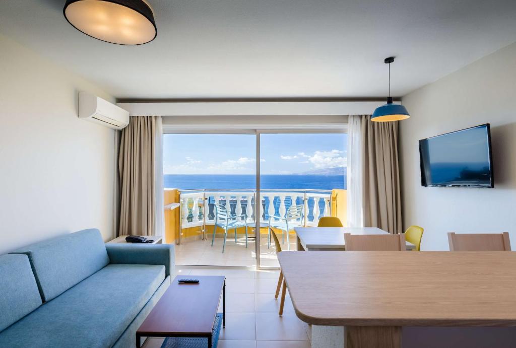 a living room with a couch and a table with a view at Allegro Isora in Puerto de Santiago