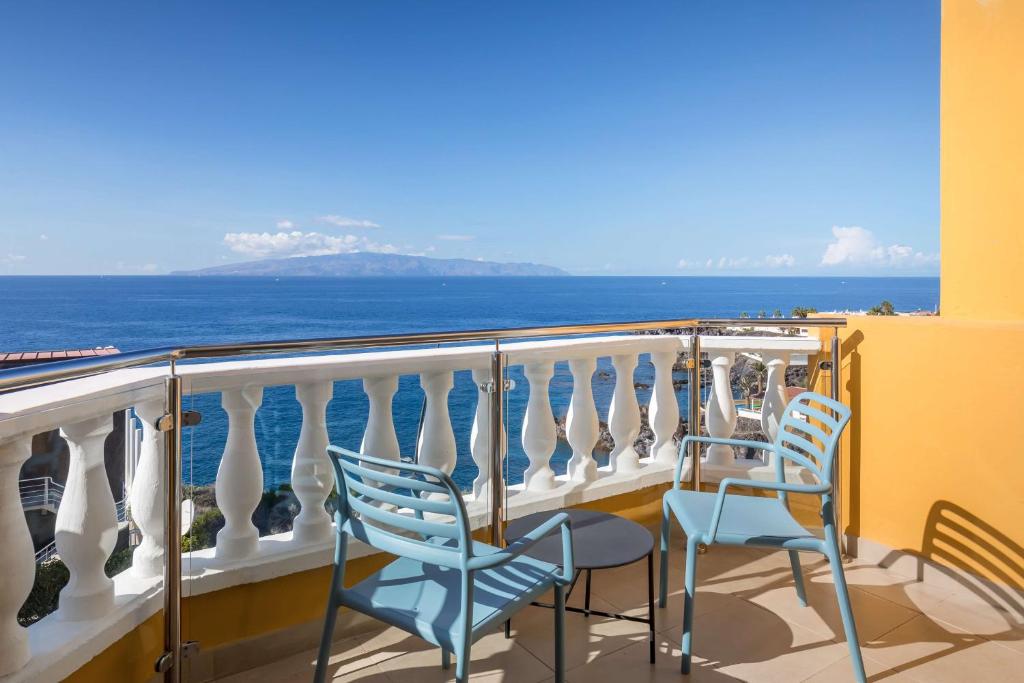 two chairs sitting on a balcony overlooking the ocean at Allegro Isora in Puerto de Santiago