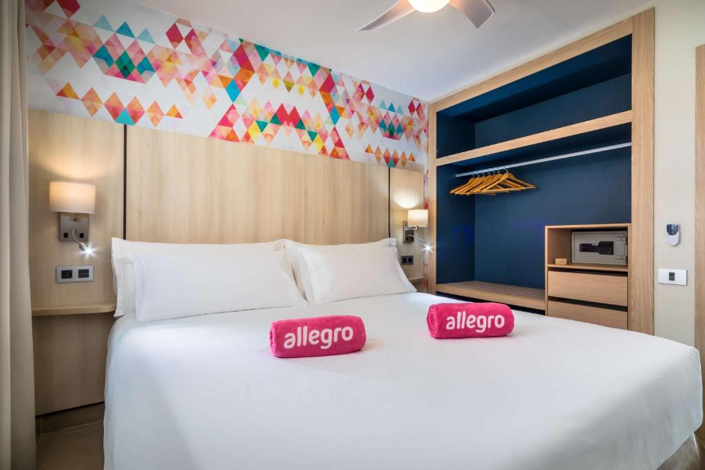 a bedroom with a large white bed with two red pillows at Allegro Isora in Puerto de Santiago