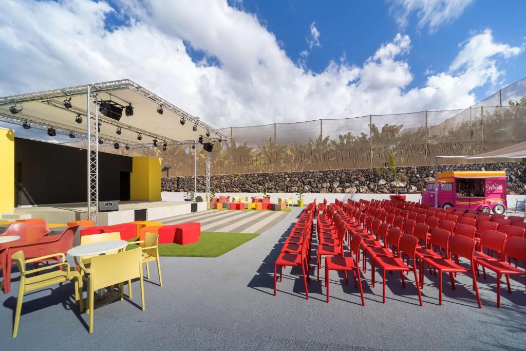 an image of a stage with red and orange chairs at Allegro Isora in Puerto de Santiago