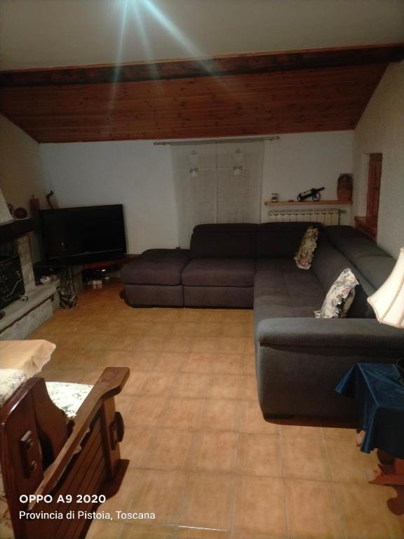 a living room with a couch and a television at Casa vacanze Abetone in Pianosinatico