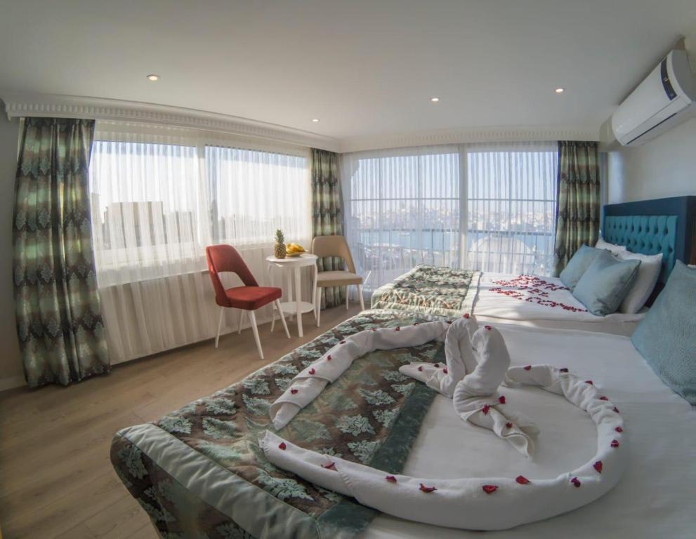 een slaapkamer met een groot bed en een kamer met: bij Grand Esen Hotel in Istanbul