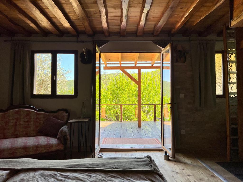 - un salon avec une porte s'ouvrant sur une terrasse dans l'établissement Les Magnels, à Valleraugue