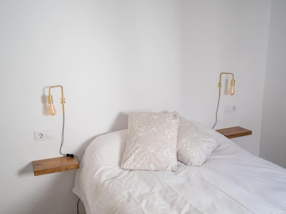 a white bed with two lights on top of it at Casa Nueva in Jimena de la Frontera
