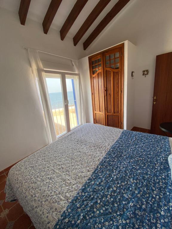 - une chambre avec un lit doté d'une couette bleue et d'une fenêtre dans l'établissement Casa en la Isla de Tabarca, à Tabarca