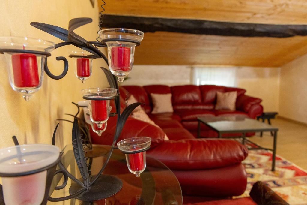 sala de estar con sofá rojo y copas de vino en Casa Vacanze Mon Rêve, en Cavalcaselle