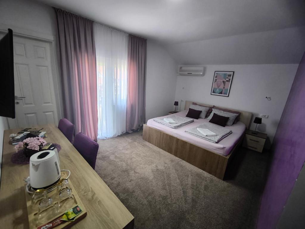 a hotel room with two beds and a table at Pansion Infinity in Mostar