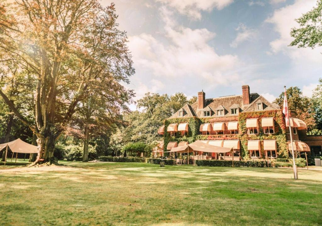 einen Außenblick auf ein großes Haus mit einem großen Hof in der Unterkunft Landgoed Huize Bergen Den Bosch - Vught in ’s-Hertogenbosch