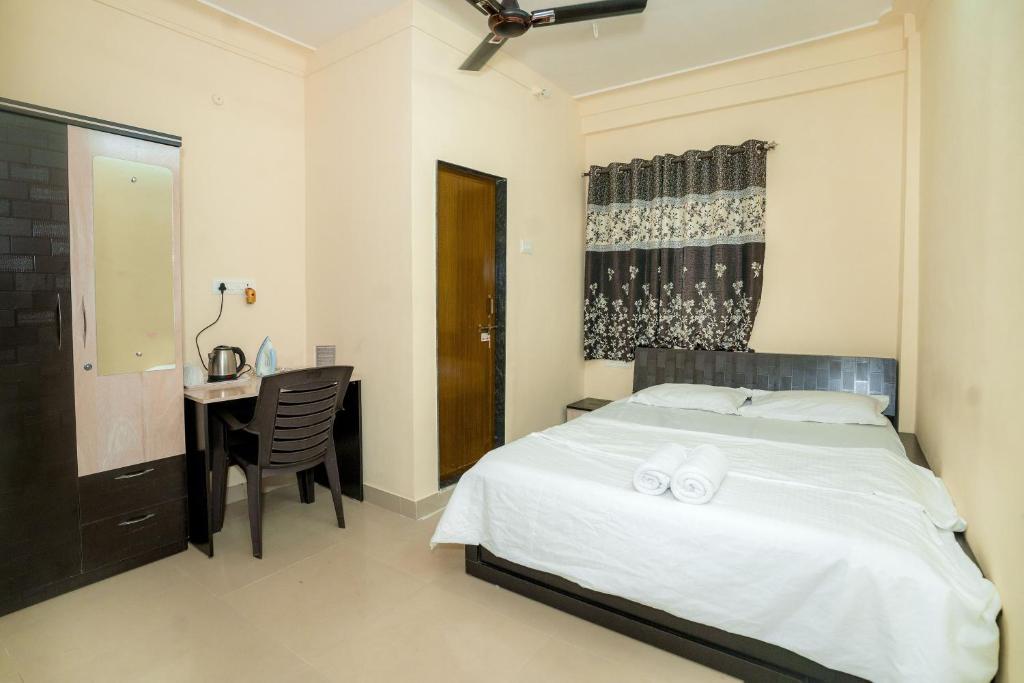 a bedroom with a bed and a desk and a table at Paradise Homestay in Pune