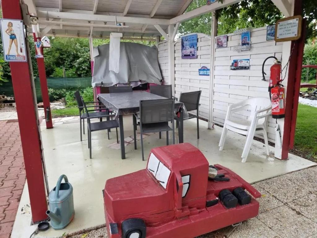 une maison avec un camion rouge sur une terrasse dans l'établissement Maison avec jardin clos et barbecue à Vendat, à Vendat