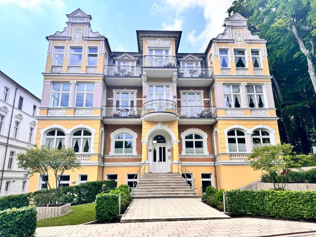 een groot geel huis met een trap ervoor bij Villa Aegir 103 in Neuhof