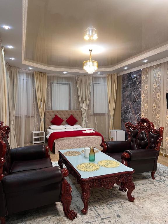 a bedroom with a bed and a couch and a table at Klass in Taraz