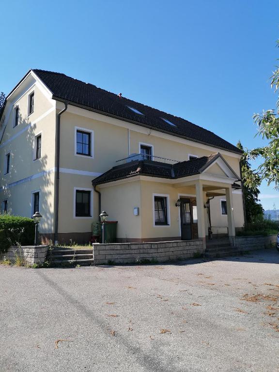 a large white house with a black roof at NA-Home Melcherhof in Grafenstein