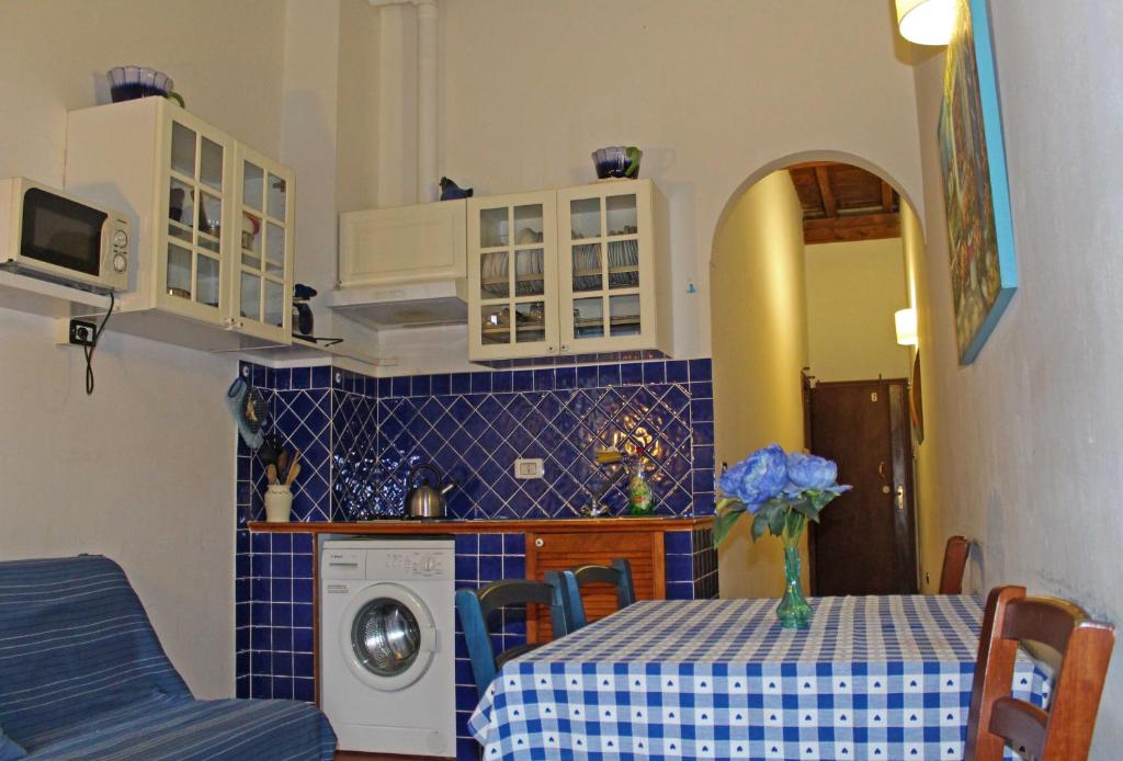 uma cozinha com uma mesa e uma máquina de lavar roupa em Max Apartments em Florença