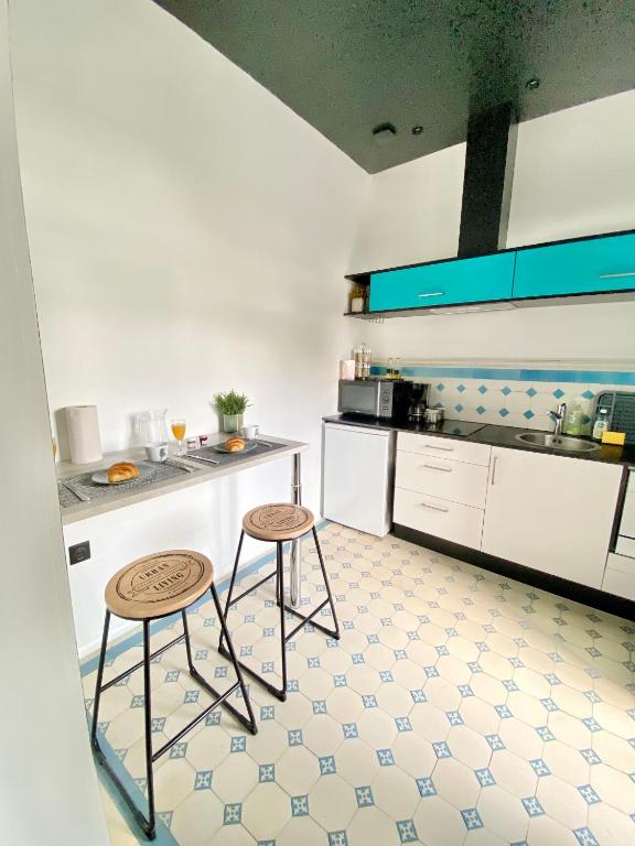 une cuisine avec deux tabourets et un comptoir dans l'établissement Le manoir des rêves, bulle de confort et de sérénité, proche clinique d'Europe, Parking privé gratuit, à Rouen