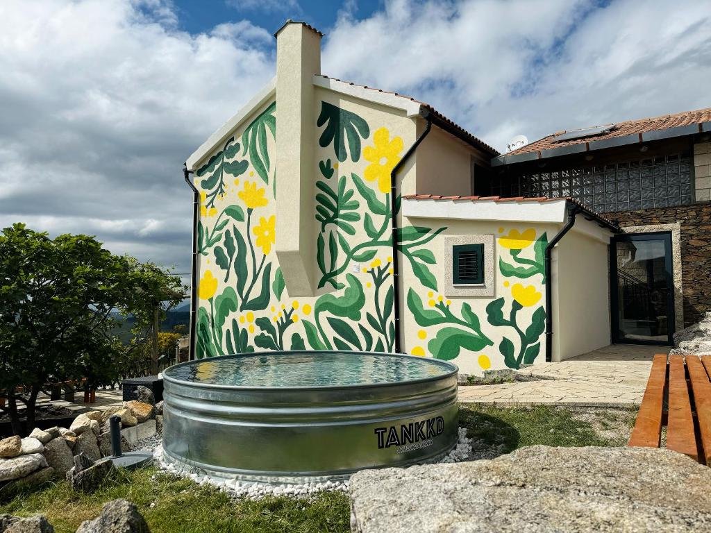 a house with a painting on the side of it at Refúgio das Carquejas 