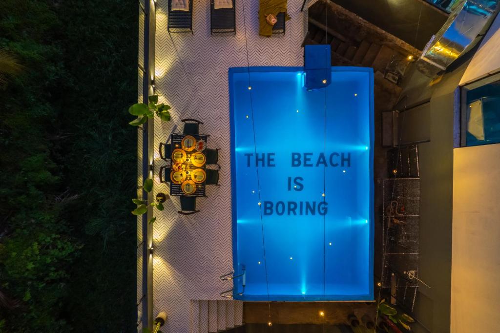 a blue sign that says the beach is boring at Minimalist Panjim in Marmagao