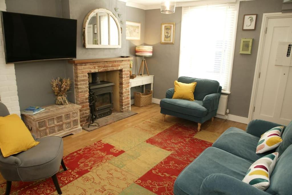 ein Wohnzimmer mit Couch und Kamin in der Unterkunft The Salty Mermaid Fisherman's Cottage, Whitstable in Kent