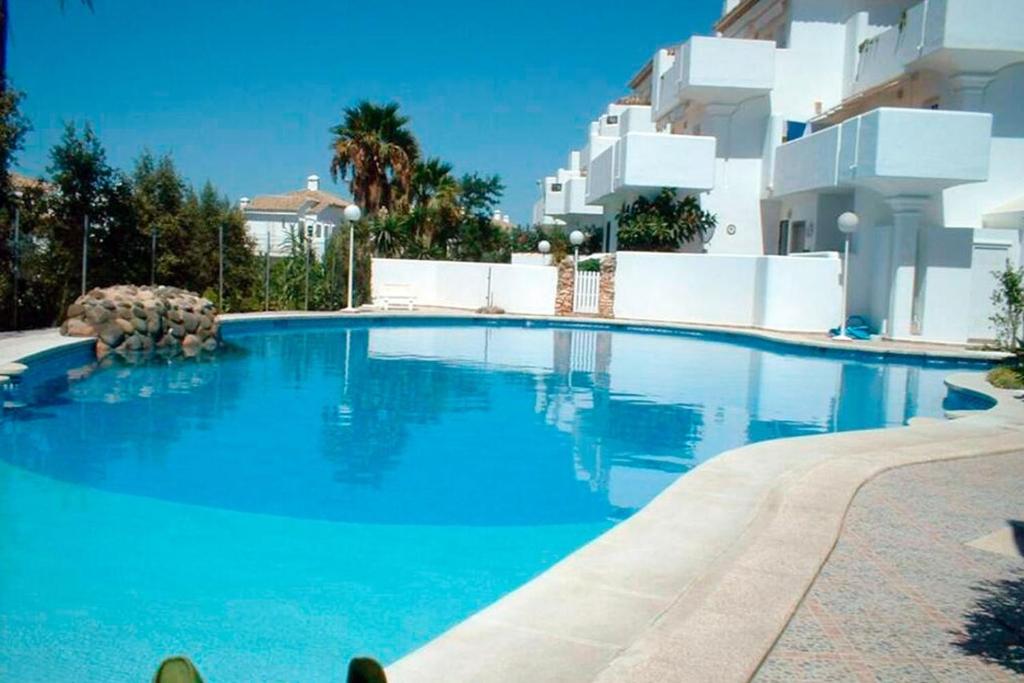 ein großer blauer Swimmingpool neben einem Gebäude in der Unterkunft La Barrosa in Novo Sancti Petri