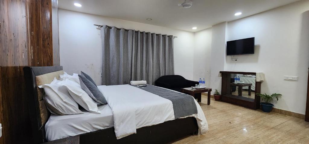 een slaapkamer met een bed en een televisie. bij Premium Hotel Deoli Khanpur in New Delhi