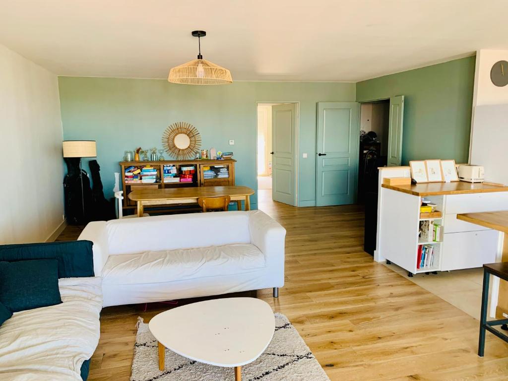 un salon avec un canapé blanc et une table dans l'établissement Charmant appartement , vue mer, à Marseille