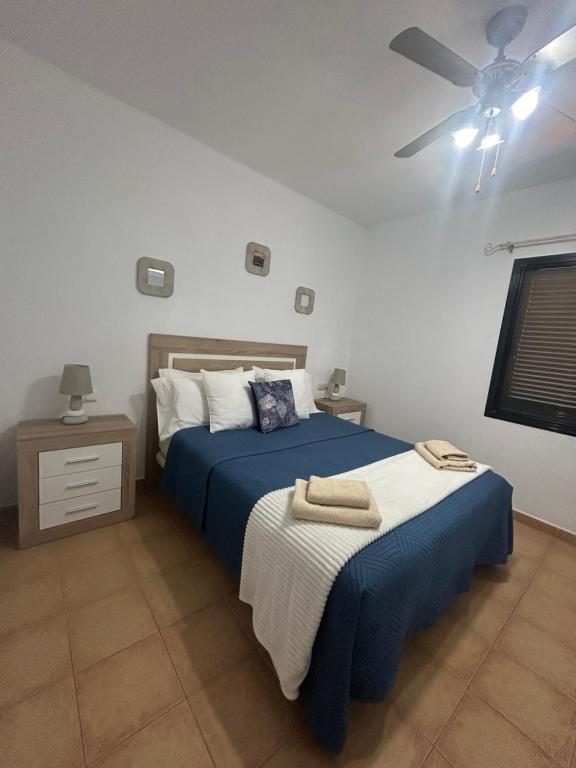 1 dormitorio con 2 camas y ventilador de techo en CASA ORILLA! Beautiful private holiday villa with hot tub, en La Oliva