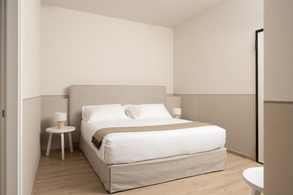 a white bedroom with a bed and a table at Villa Il Platano in Como