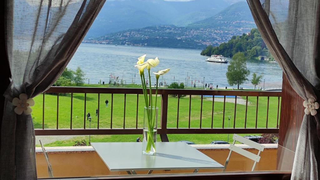 a vase with flowers on a table in front of a window at Lily Lake Maggiore in Laveno