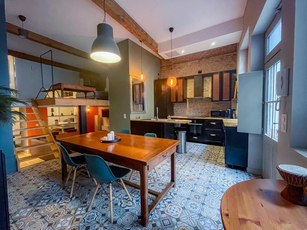 une grande cuisine avec une table et des chaises en bois dans l'établissement Hiding Place - Loft Toulousain Unique, à Toulouse