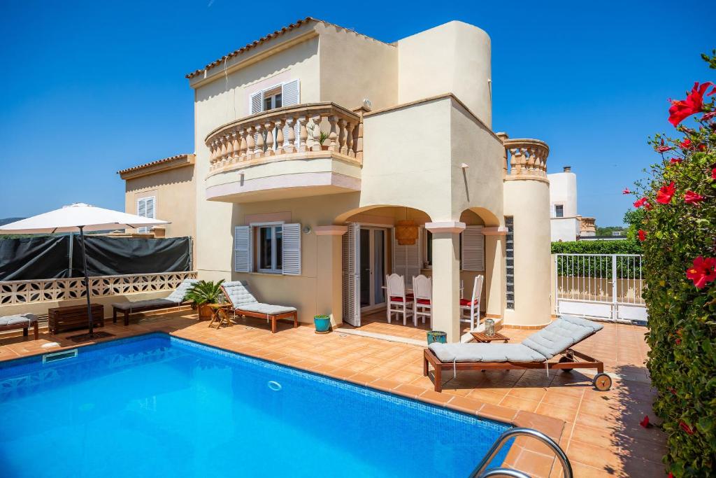 a villa with a swimming pool in front of a house at Villa Sion in Cala Mendia