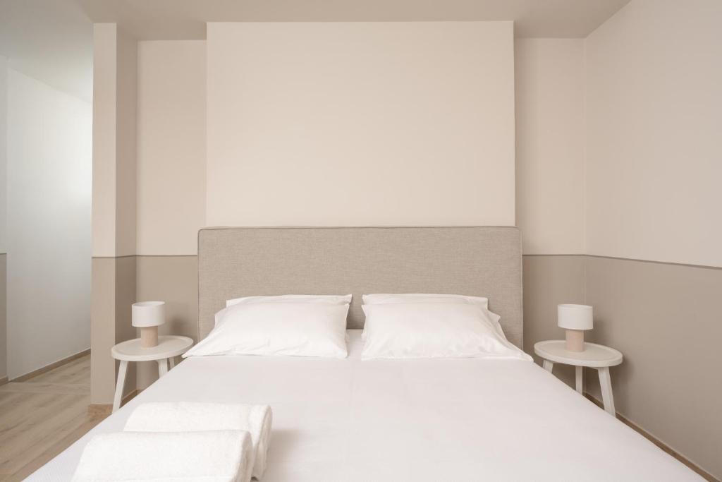 a white bedroom with a large white bed with two tables at Villa Il Platano in Como
