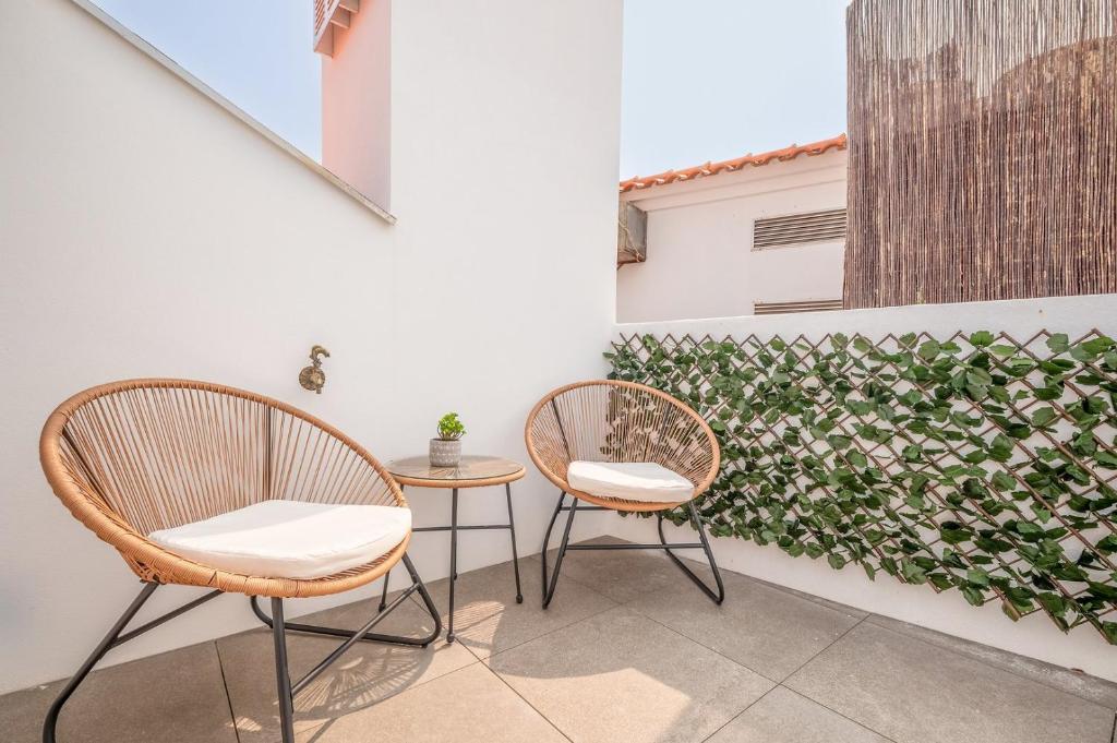 two chairs and a table on a balcony at GuestReady - Beachfront dream in Sesimbra in Sesimbra