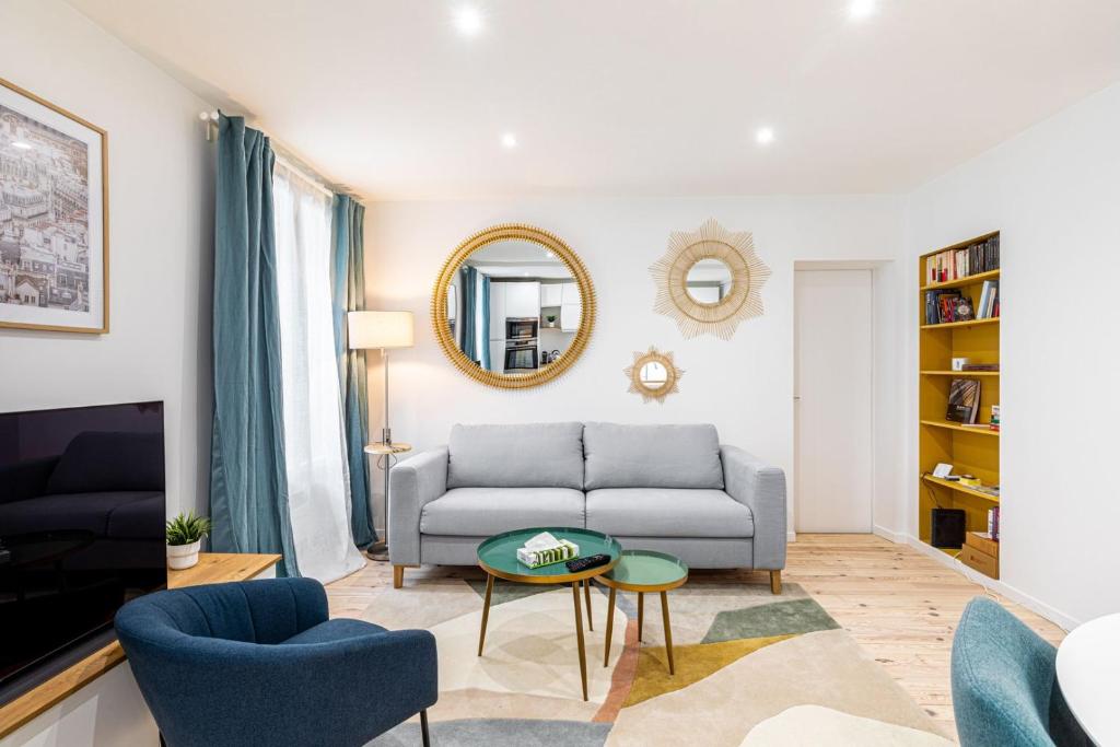 een woonkamer met een bank en een tafel bij GuestReady - Glamourous getaway in the 20th Arr. in Parijs