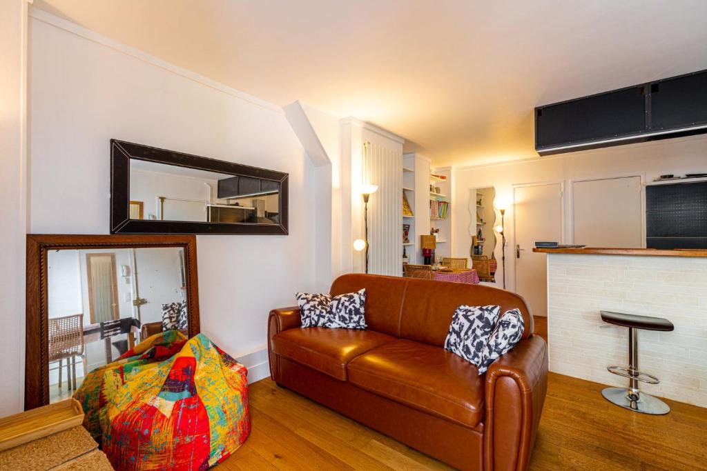 - un salon avec un canapé en cuir et un miroir dans l'établissement GuestReady - Magic View Montparnasse Big Terrace, à Paris