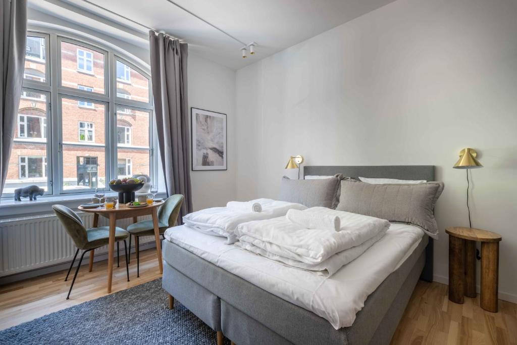 a bedroom with a bed and a table and a window at Perfect Couples Retreat in Urban Area in Copenhagen