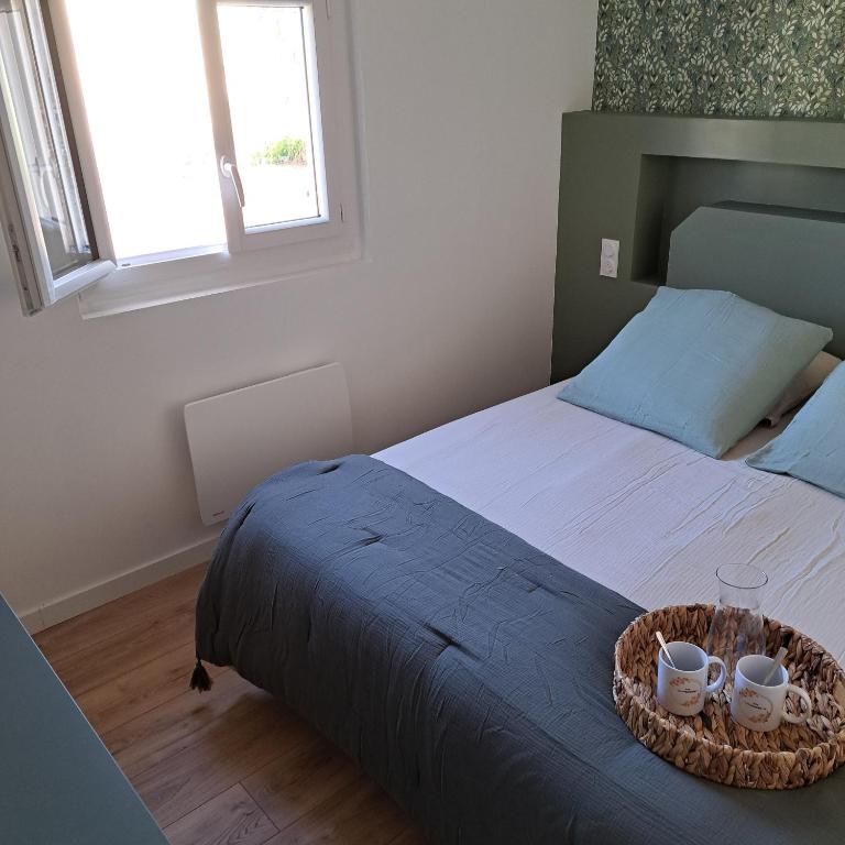 - une chambre avec un lit et deux tasses dans l'établissement Gîte Les Pâquerettes, à Bretteville-du-Grand Caux