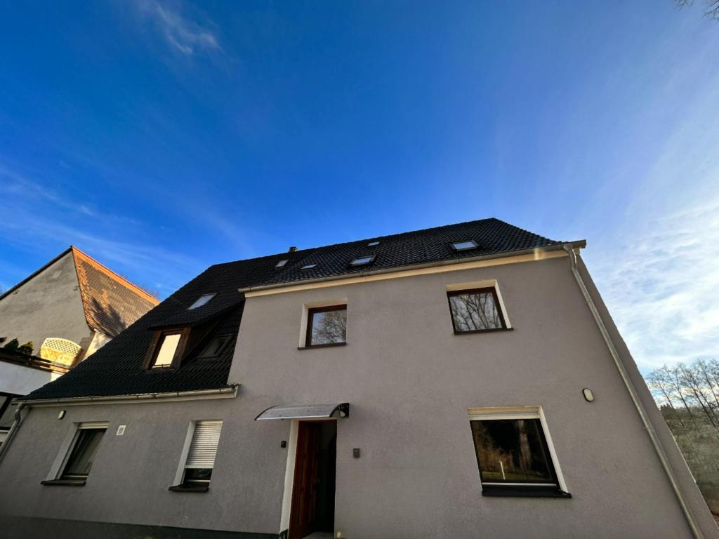 ein weißes Haus mit schwarzem Dach in der Unterkunft Monteurunterkunft Schwarzenbruck in Schwarzenbruck