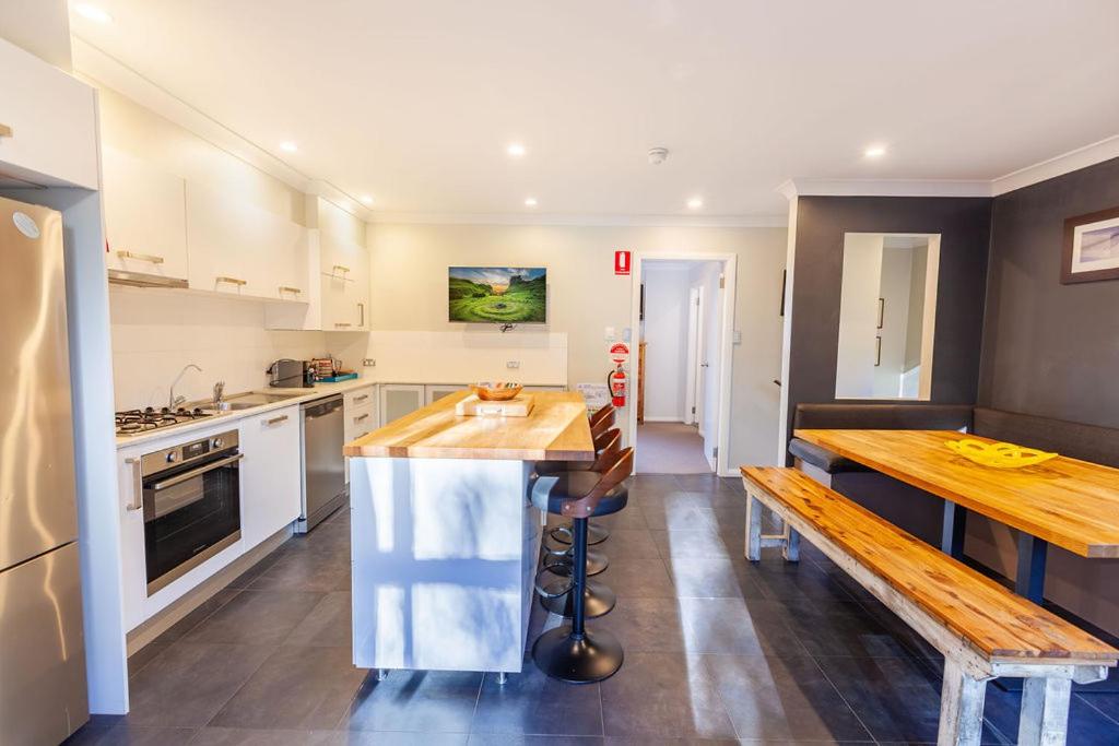 uma cozinha com uma mesa e um banco em Snowcreek 2 Alpine Chalet, Private Garage em Thredbo