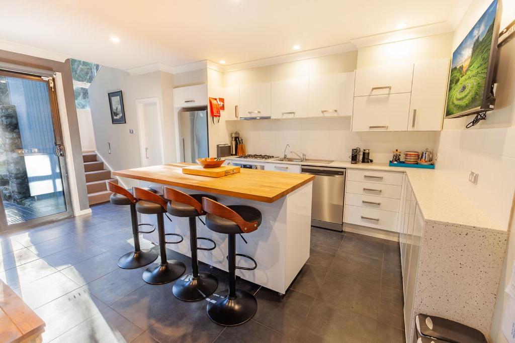 a kitchen with a wooden counter and bar stools at Snowcreek 2 Alpine Chalet, Private Garage in Thredbo