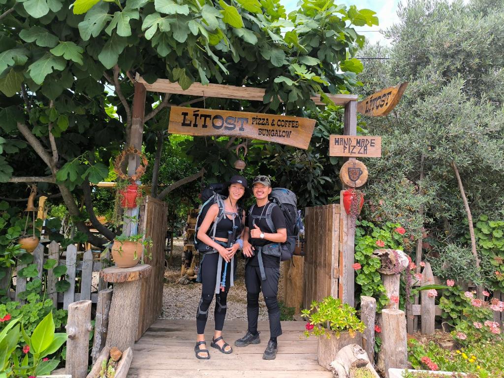 duas mulheres em frente a um portão de jardim em Litost Cafe Bungalow em Adrasan