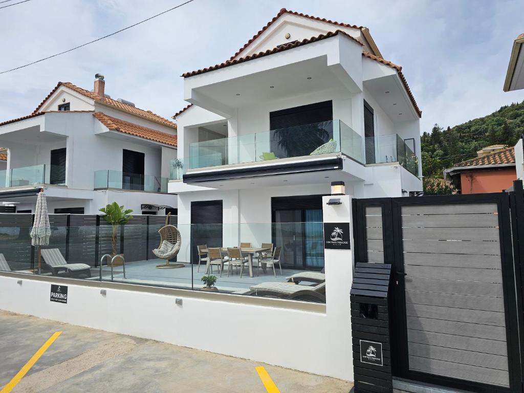 a white house with a balcony with a patio at Dimitra's Paradise Villa in Lygia