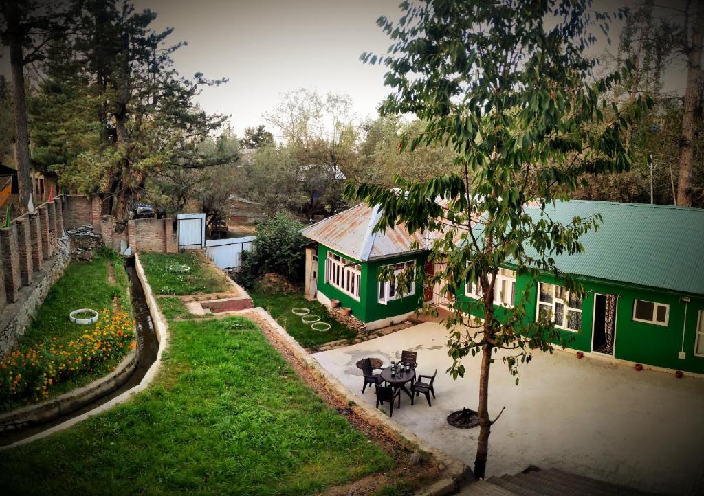 a green house with a table in a yard at Serene Stay Villa by Doctors in Gulmarg