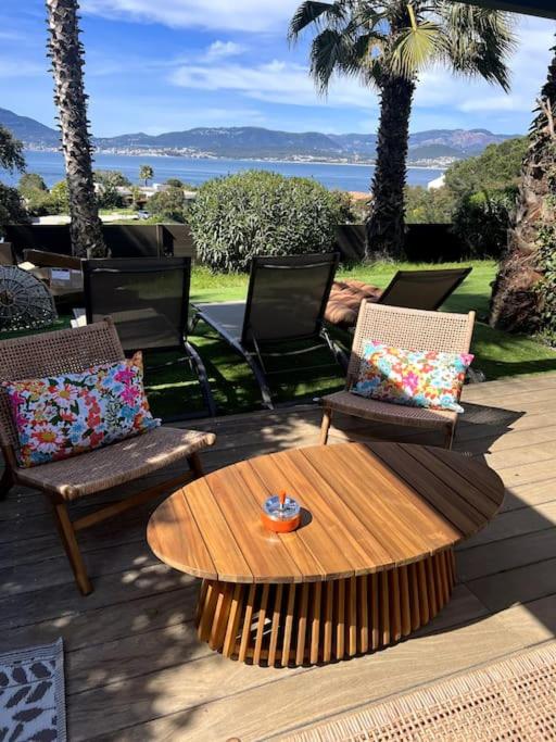 d'une terrasse avec 2 chaises et une table en bois. dans l'établissement Appartement T2 Vue Mer Porticcio, à Porticcio